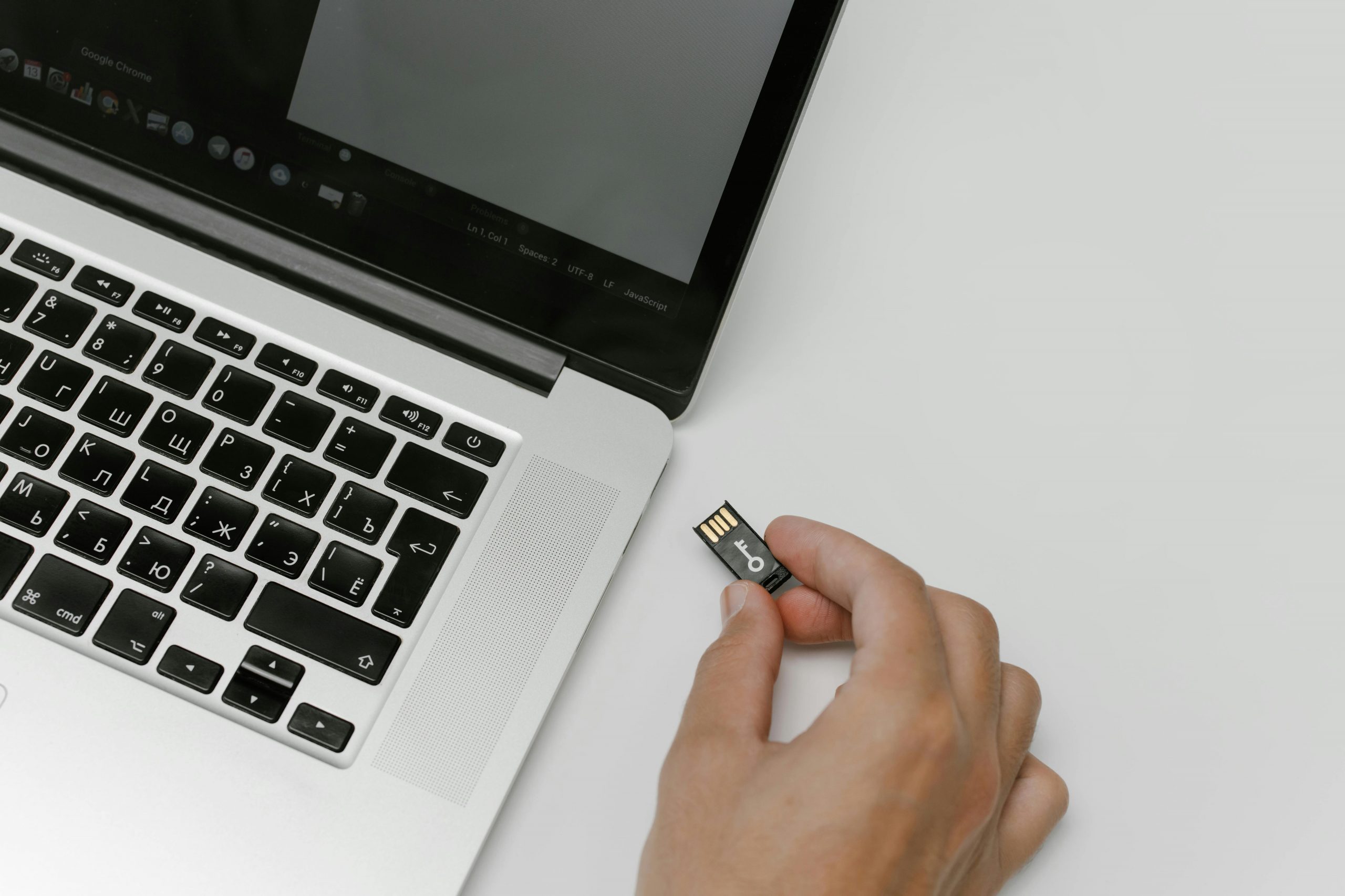 hand inserting an SD card into a laptop's card slot