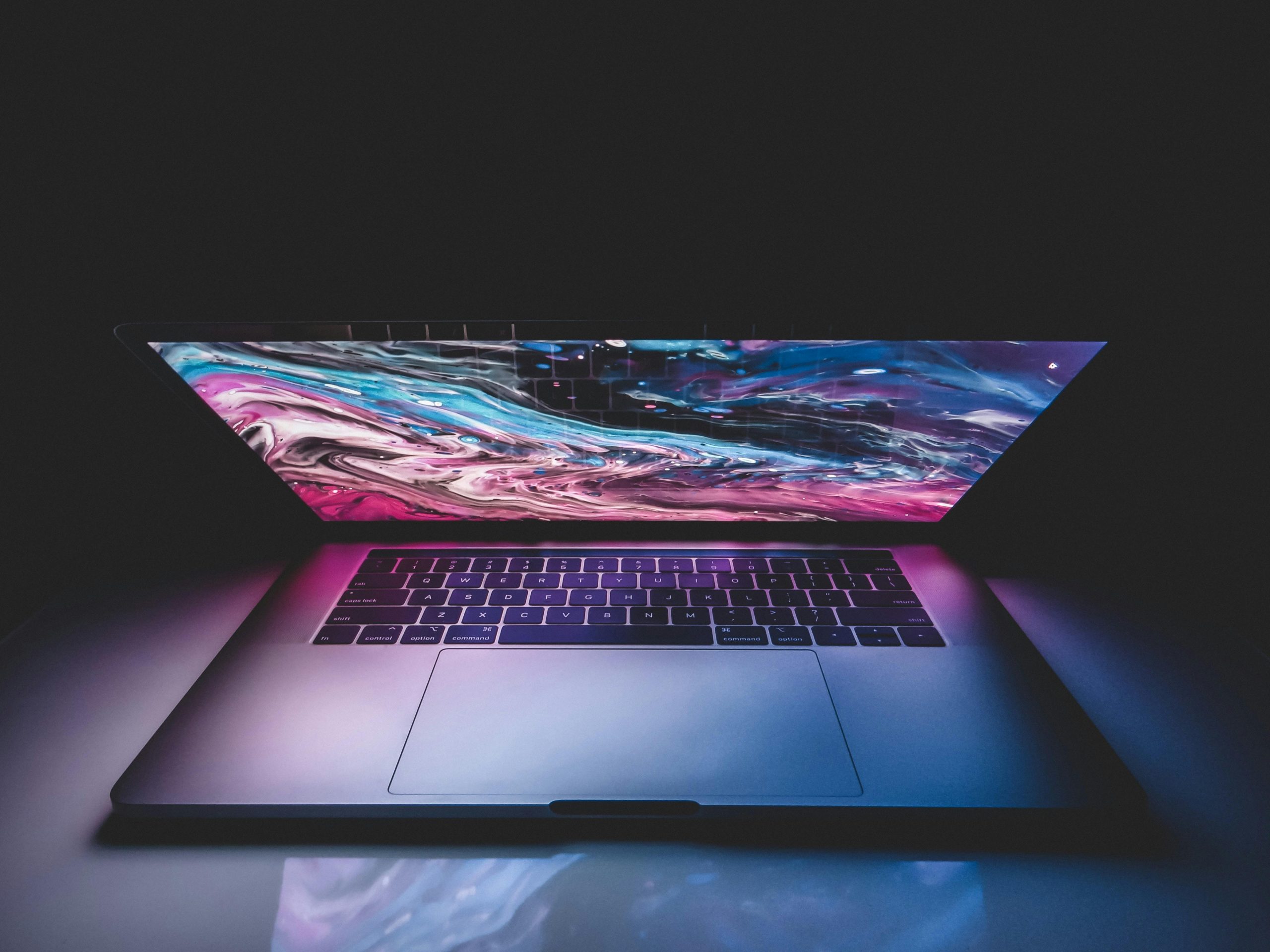 half-open laptop displaying a vibrant galactic image on the screen