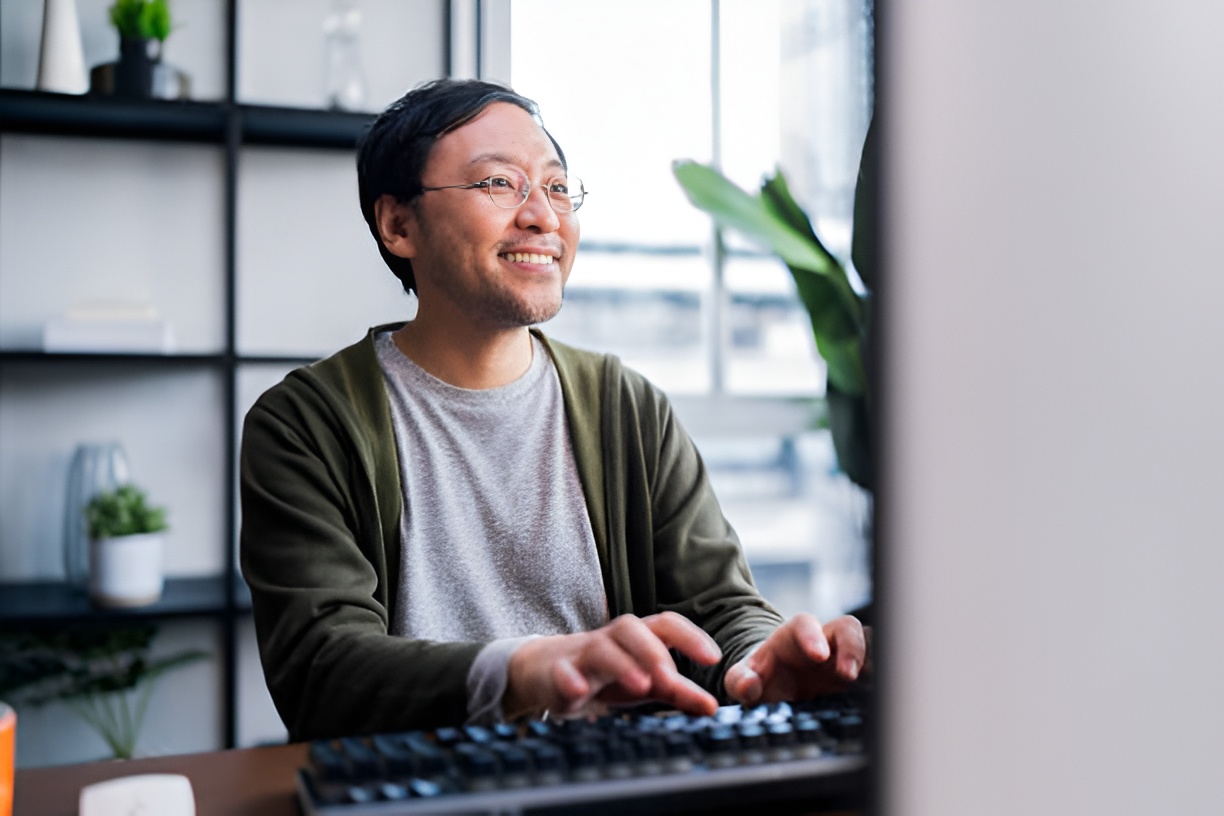 smiling man using a desktop computer