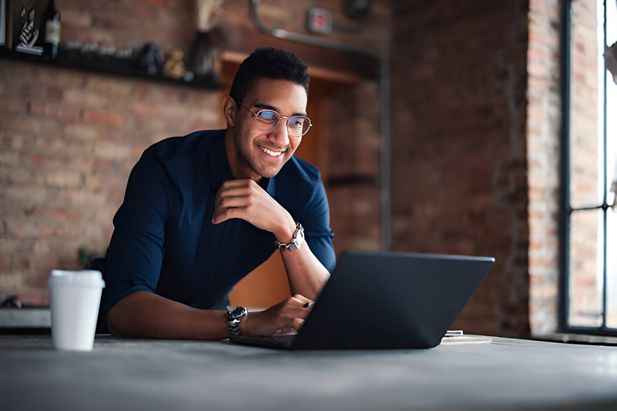 smiling man using a laptop